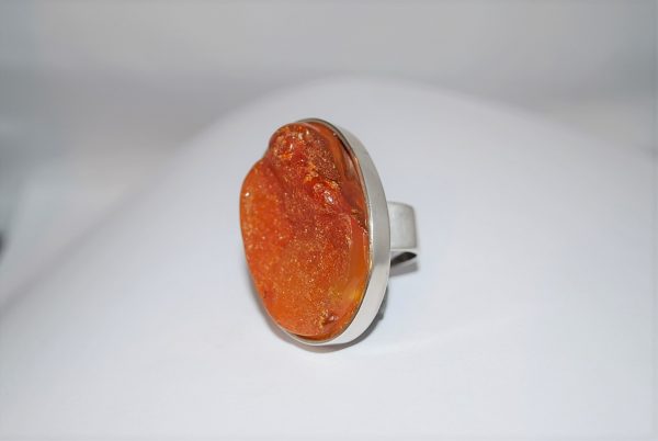 Ring med stort ovalt ravstykke i natur.