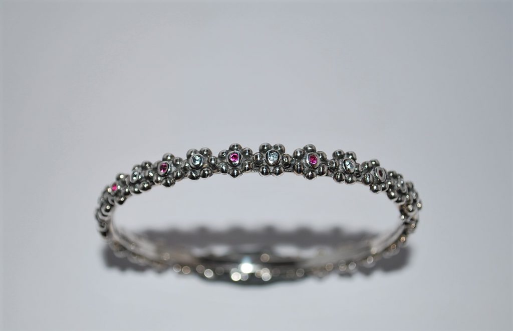 Fast armring,let oxyderet, blomster med skiftevis hvide og pink cubisk zirkon.
