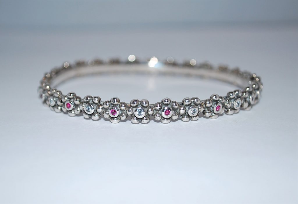 Fast armring,let oxyderet, blomster med skiftevis hvide og pink cubisk zirkon.